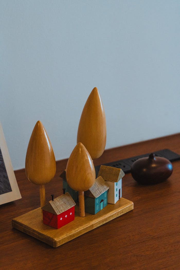 about-us Aesthetic minimalist wooden toy houses and trees on a wooden desk, perfect for home decor.