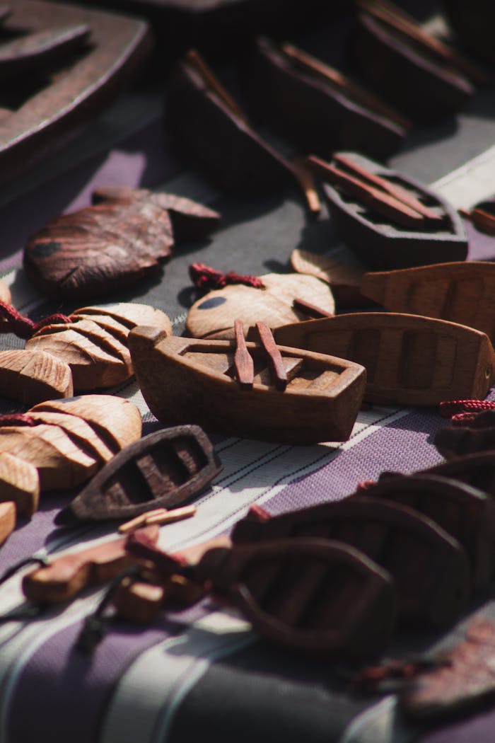 services-04 Intricately carved wooden boats and figures showcased outdoors in Alger, Algeria.